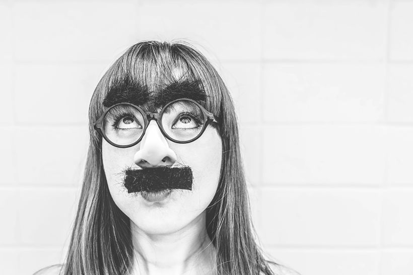 Una mujer lleva postizos de bigote y gafas con cejas