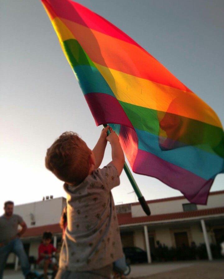 Un niño ondea una bandera del Orgullo, en el municipio cacereño de Pizarro. / Foto: Cedida