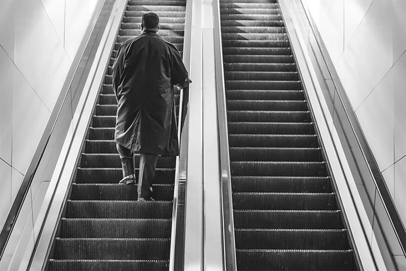 Un hombre aparece de espaldas subiendo unos escalones en una foto en blanco y negro