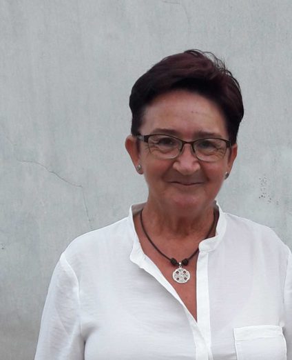 Una mujer con pelo corto y camisa blanca posa a medio cuerpo.