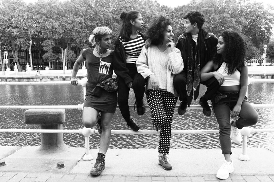 Fotografía en blanco y negro. Cinco mujeres posan apoyadas en una barandilla de la ría