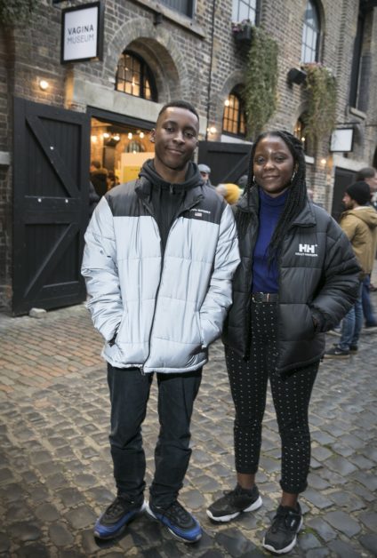 dos personas, un chico y una chica, posan a la puerta del museo de la vagina