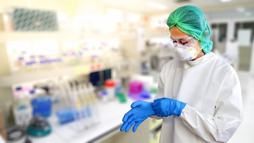 Una mujer se coloca el traje de protección en un laboratorio