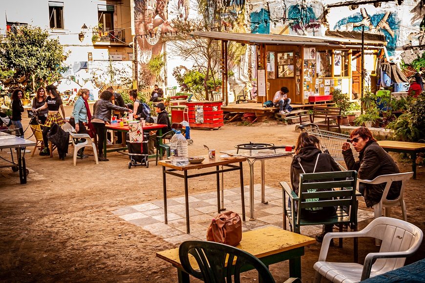 en un patio decorado con plantas, grupos de mujeres charlan