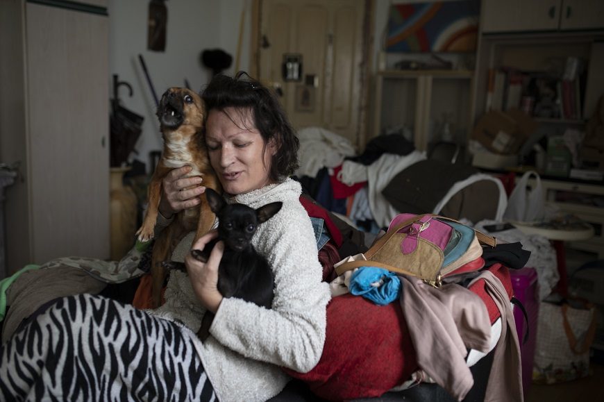 una mujer sentada en su casa abraza a su perra