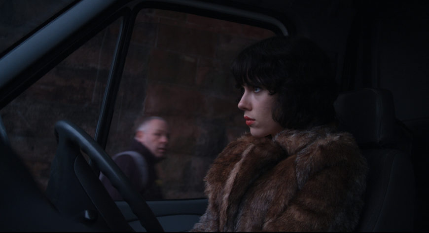 Scarlett Johansson en un fotograma de Under the skin, sentada en el interior de un coche con un abrigo de piel.