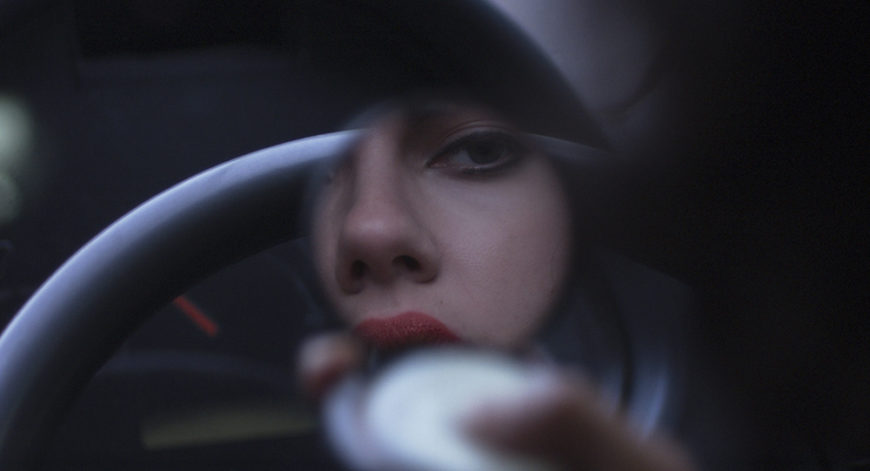 Under the skin, plano detalle de un ojo y parte de los labios de Scarlett Johansson, reflejados en un espejo. 