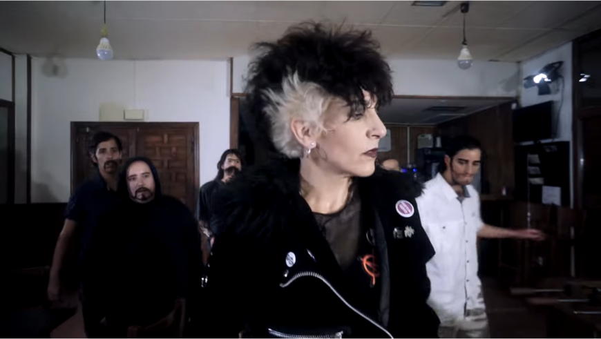 Fotograma del videoclip de punk feminista donde Belén Nevado aparece en un bar con varios hombres que la siguen