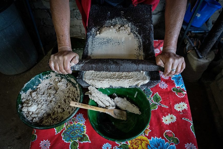 unas manos trabajan en un metate