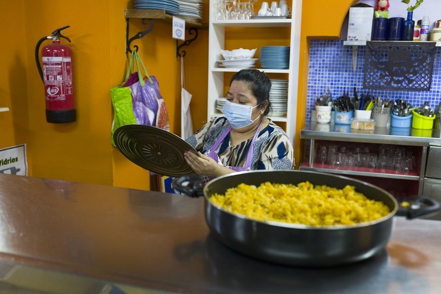 Una mujer limpia los trastos de la comida