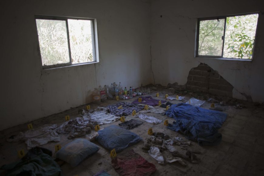 una habitación de una casa abandonada con un montón de ropa en el suelo con marcas de que son pruebas