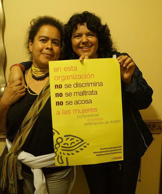 dos mujeres juntas sostienen un cartel