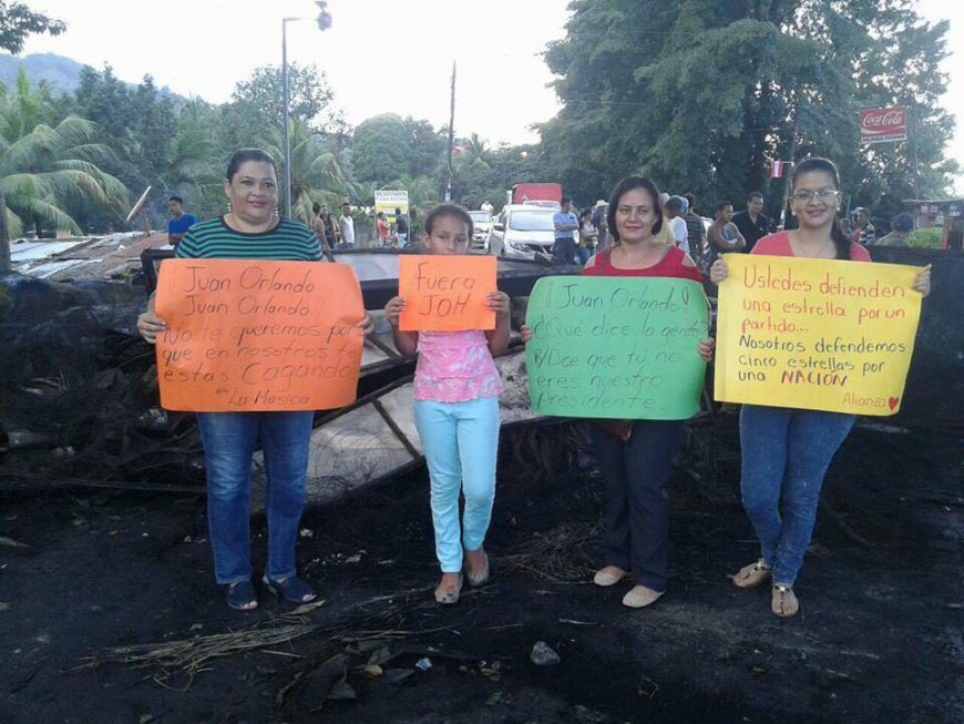 cuatro mujeres posan con cartulinas a modo de carteles