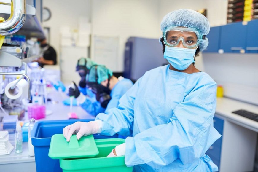 una mujer negra con una EPI en un laboratorio