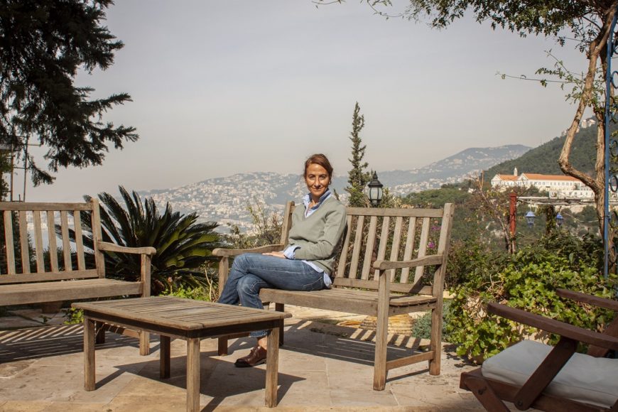 una mujer sentada en una casa con una vistas sobre la ciudad