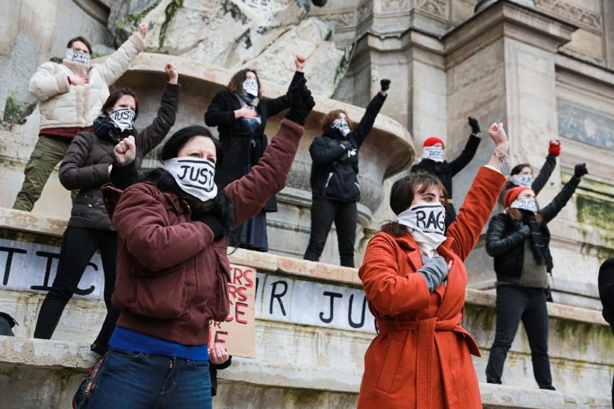 contrapicado de unas manifestantes con el brazo izquierdo en alto