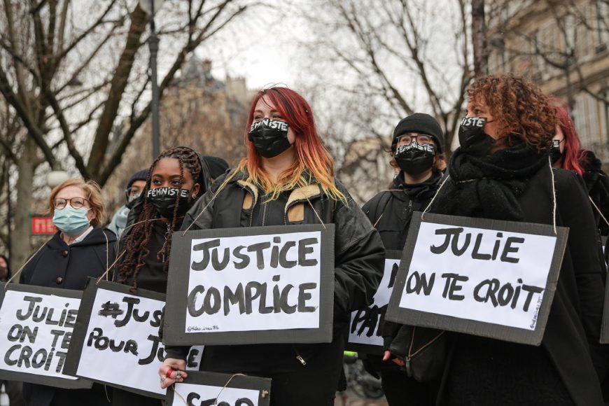 un grupo de mujeres, vestidas casi todas de negro, con carteles que reclaman justicia, llevan también mascarillas negras