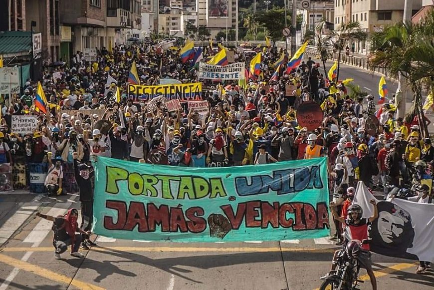 mucha gente detrás de una pancarta