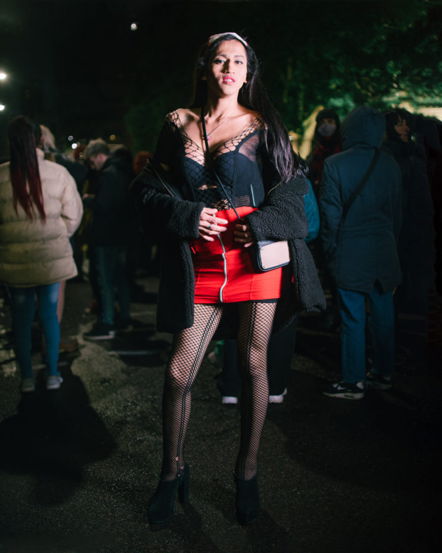 En la imagen aparece una mujer de cuerpo entero, con falda roja, durante una manifiestación en La Plata.