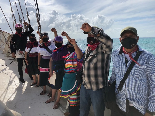 un grupo de zapatistas en el barco con un brazo en alto