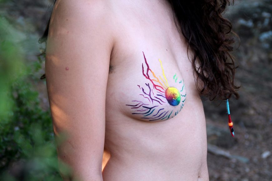 un torso desnudo de perfil con el pezón pintado de colores