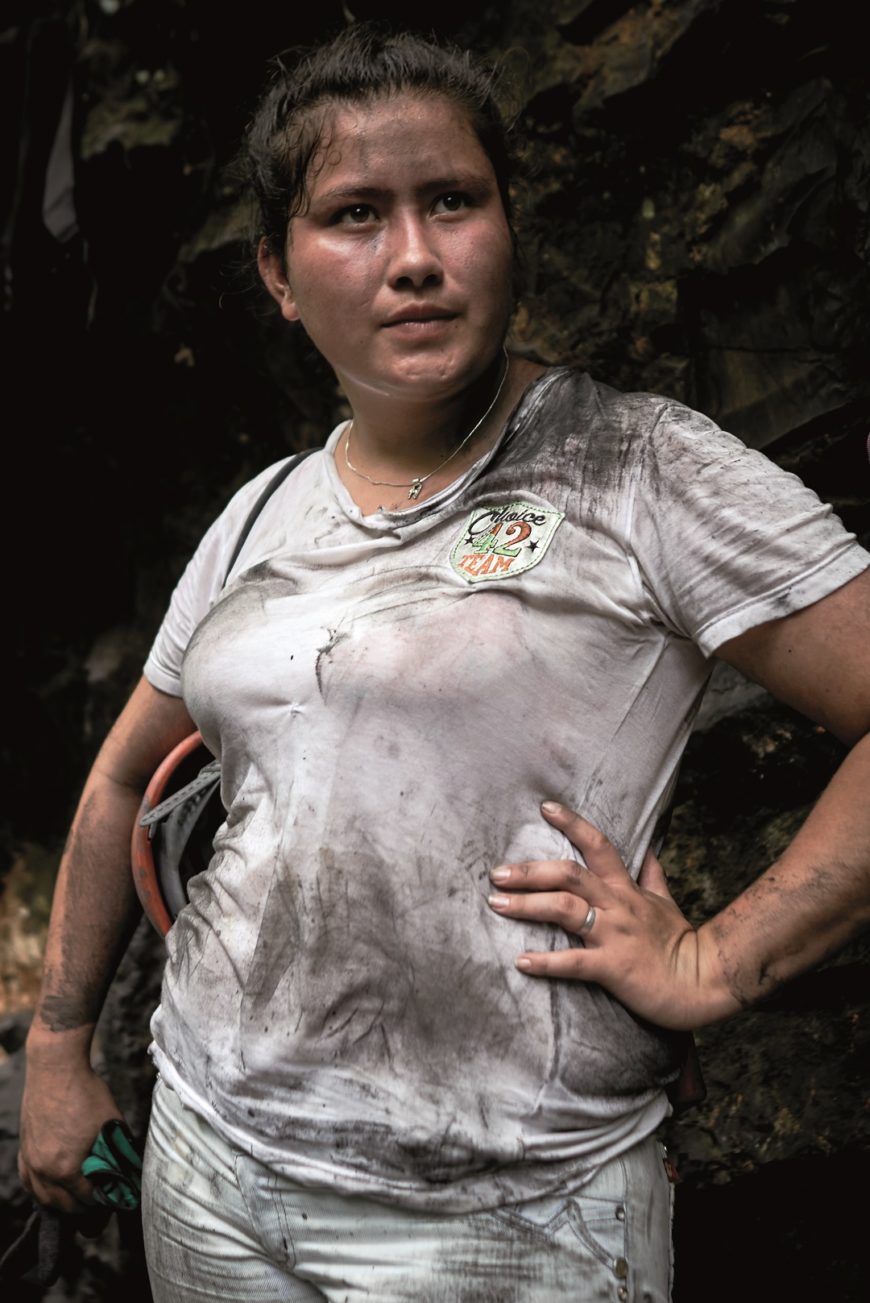 una mujer con casco minero en la mano