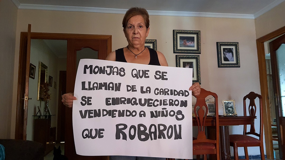 una mujer con una pancarta en el salón de su casa