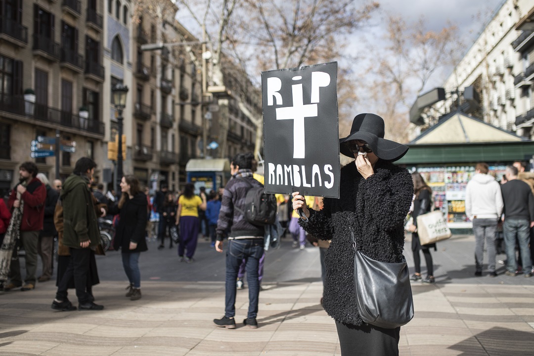 una mujer de luto llora con un cartel que pone RIP Ramblas