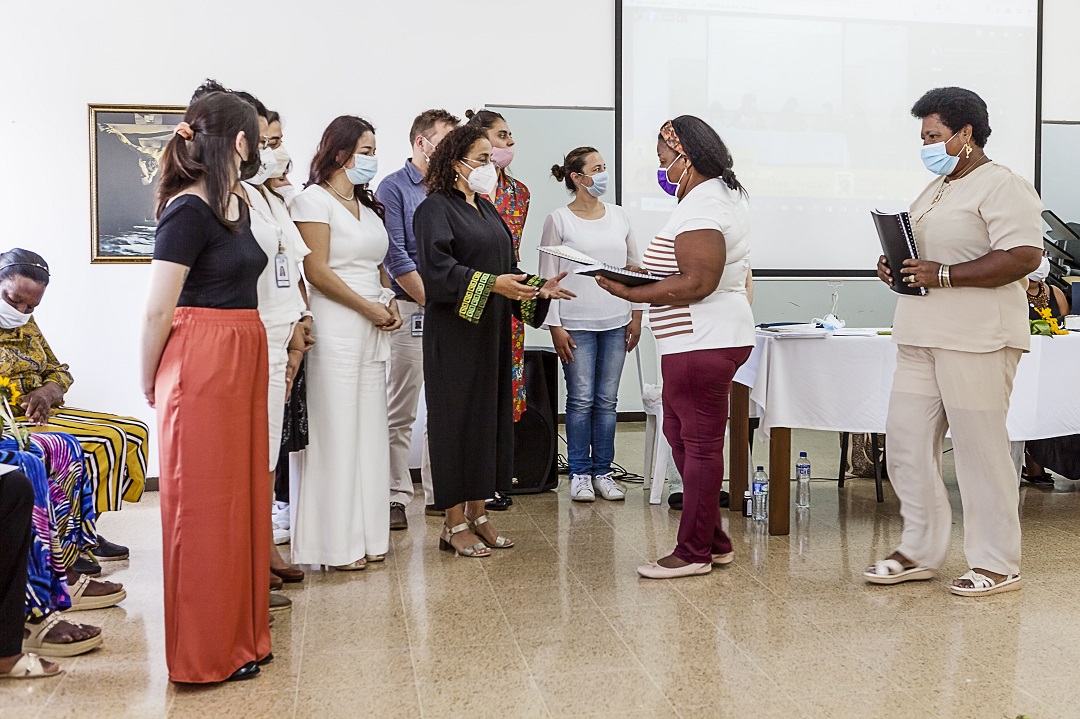 varias mujeres entrega un documento a otras, una de ellas con toga