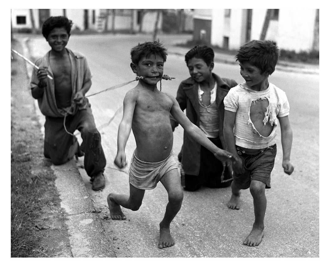 foto en blanco y negro de unos niños semidesnudos jugando en la calle